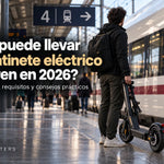 Viajero con patinete eléctrico en una estación de tren, ilustrando la normativa de Renfe 2026 y los requisitos para transportar patinetes.